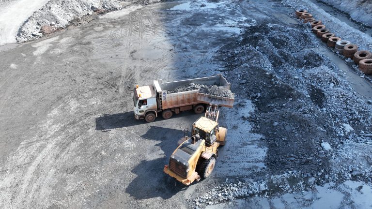 Chargeuse sur pneus remplissant un camion-benne sur un site d'exploitation