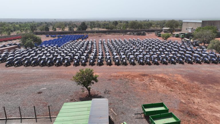 Parc de tracteurs du groupe près de Bobo-Dioulasso : parc de tracteurs bleus, bâtiments au fond, vue aérienne de janvier 2026
