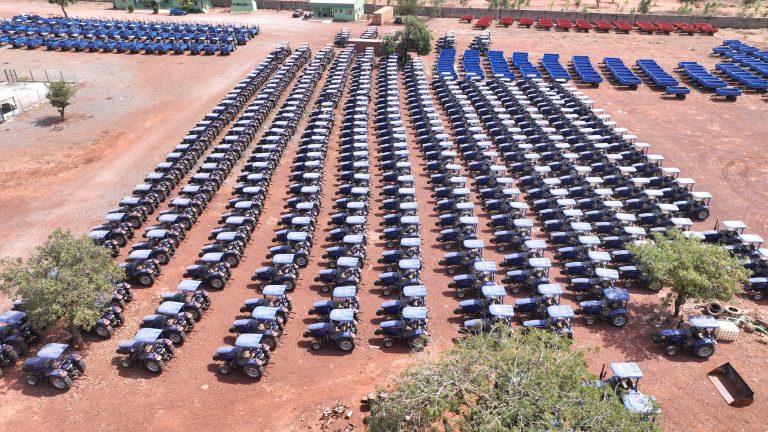 Parc de tracteurs du groupe près de Bobo-Dioulasso : des dizaines de rangées de tracteurs bleus, vue aérienne de janvier 2026